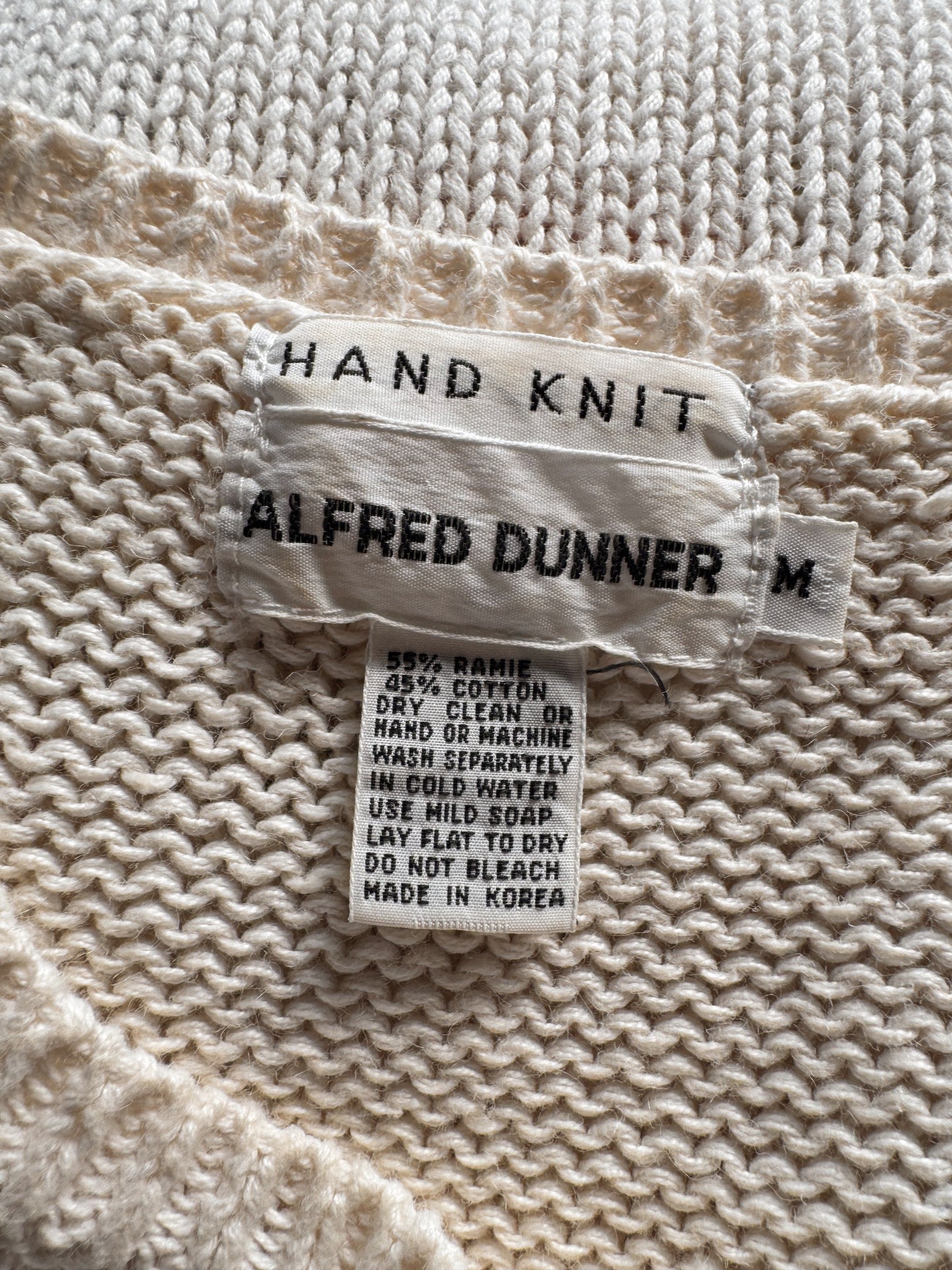 Close-up of a hand knit label on a textured fabric background