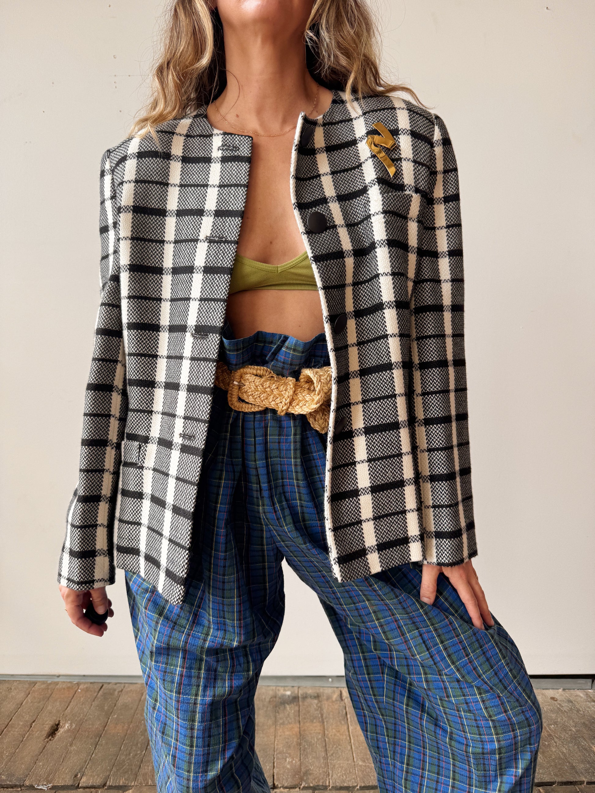 Person wearing a plaid jacket and blue pants with a white background