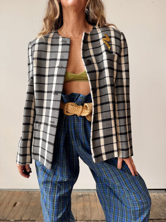 Person wearing a plaid jacket and blue pants with a white background