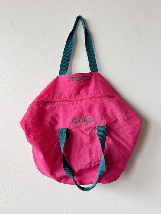 Pink tote bag with blue handles on a light gray background
