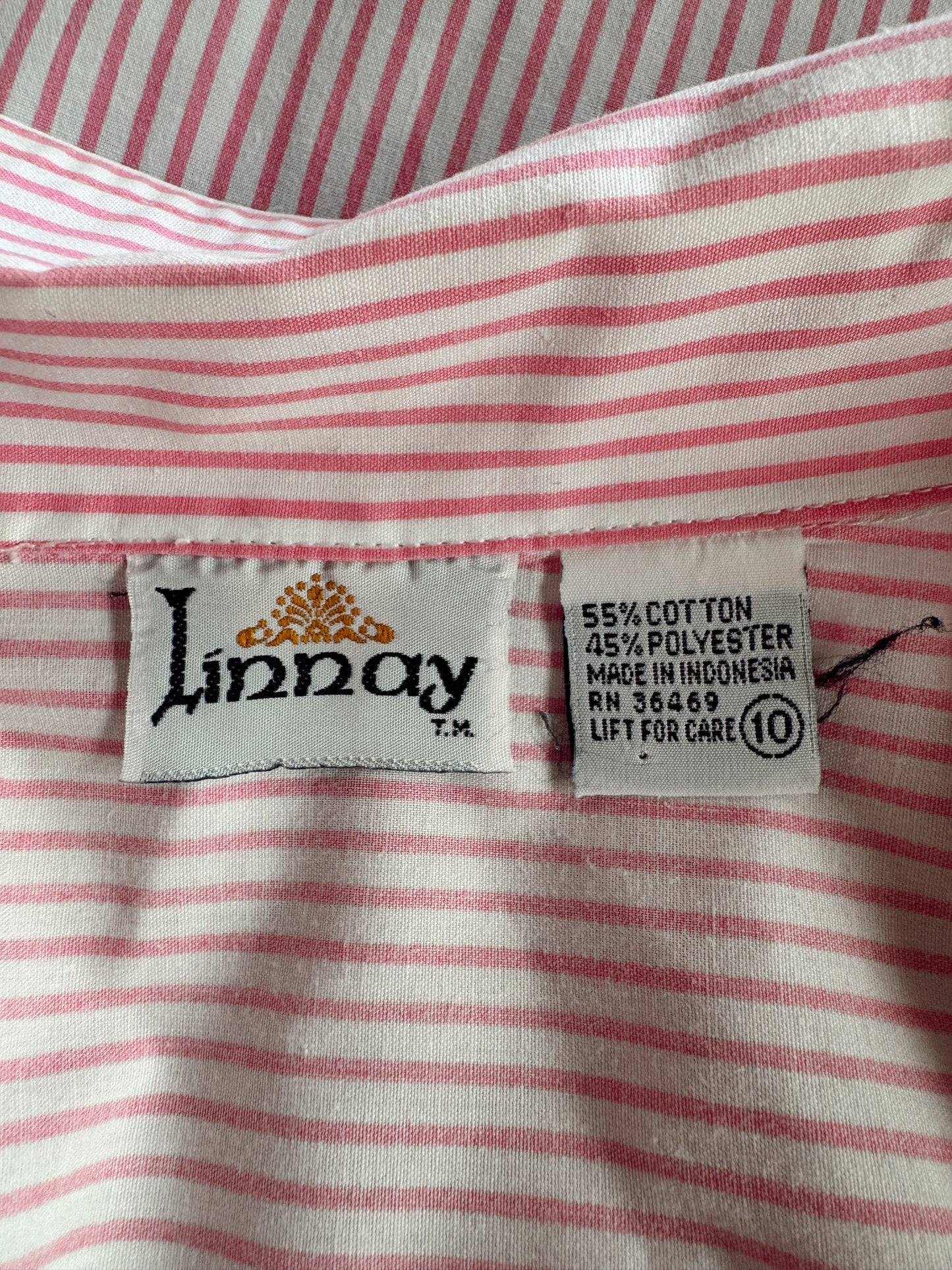 Close-up of a pink and white striped garment showing the inner neck label, which reads 'Linnay' and '55% COTTON 45% POLYESTER MADE IN INDONESIA'.